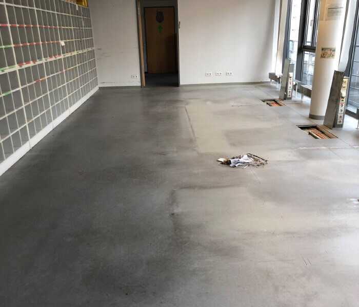 großflächiger PVC Fußbodenbelag vor der Sanierung: stark abgenutzte Oberfläche, Flecken und gebrauchsspuren