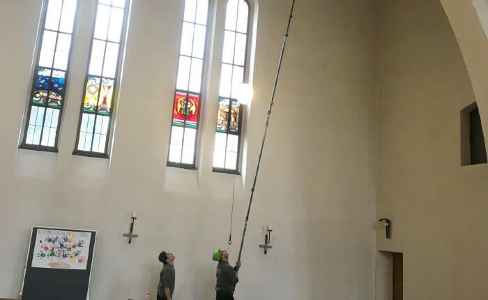Entfernen von Spinnweben in der Kirche Maria Hilf in Stadtbergen bei Augsburg durch Carbonstangen in einer Höhe von 15 Metern mit Spezialbürsten